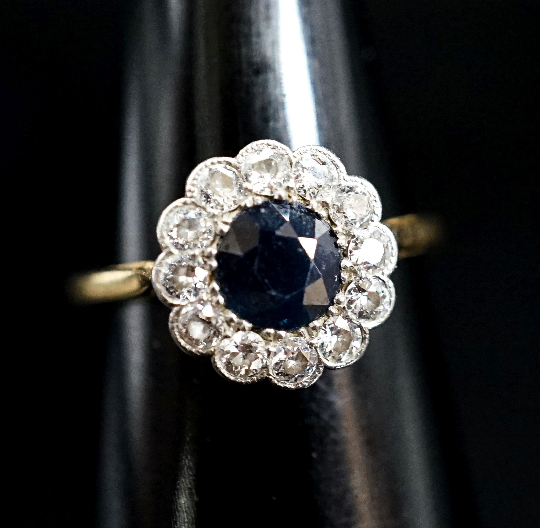 An 18ct, sapphire and diamond set circular cluster ring, size M, gross weight 2.4 grams.